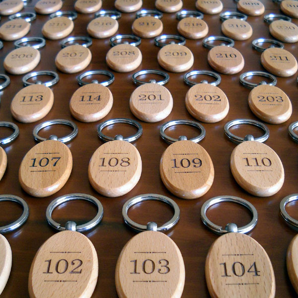 Portachiavi ovali in legno massello personalizzati con numeri camere di albergo e logo